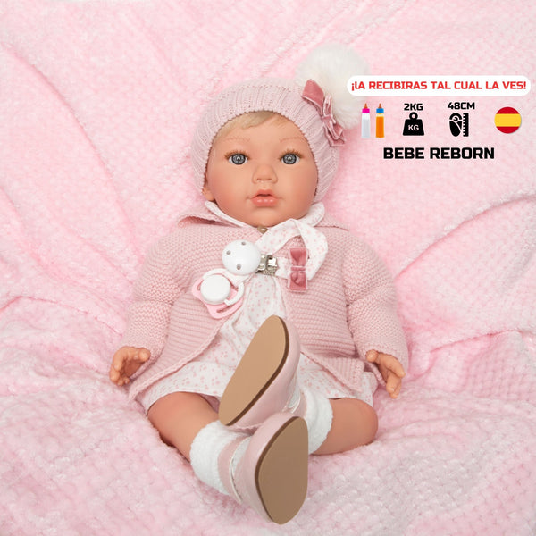 Bebe reborn de vinilo y cuerpo de tela de 48cm, zapatos, efecto caída de cabeza sentada en su manta rosa
