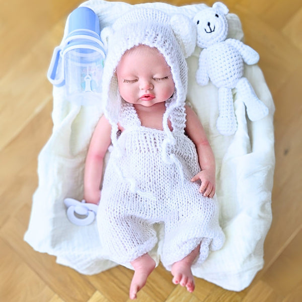 Bebé reborn silicona Leo, 40cm, niño, pelo pintado a mano tumbado sobre su manta blanca